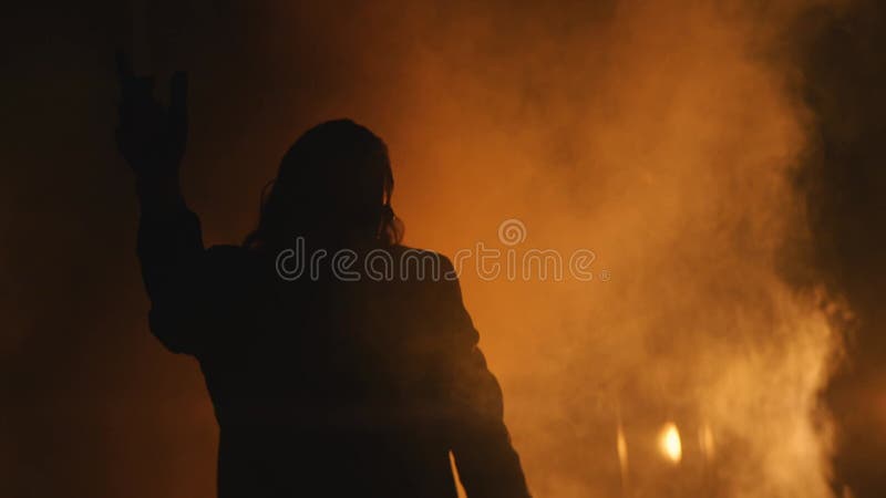 Een man danst in rook en spotlight