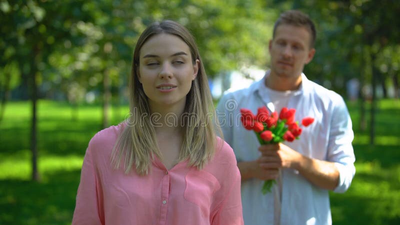 Een man die een stel bloemen meeneemt, een geërgerde dame die wringt, een ongeëvenaarde liefde