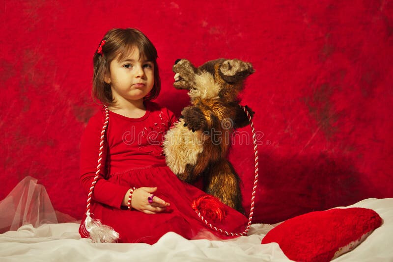 Een meisje die in rood een kleine slechte wolfsmarionet koesteren stock foto Een meisje die in rood een kleine slechte wolfsmarionet koesteren stock foto