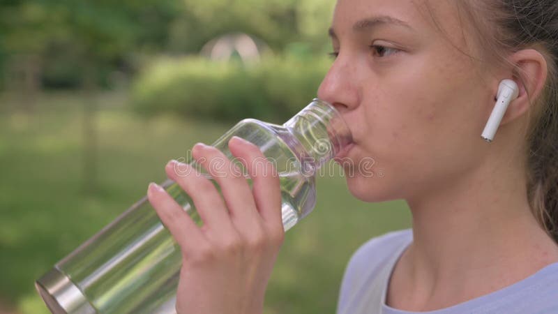 Een meisje drinkt water na het lopen