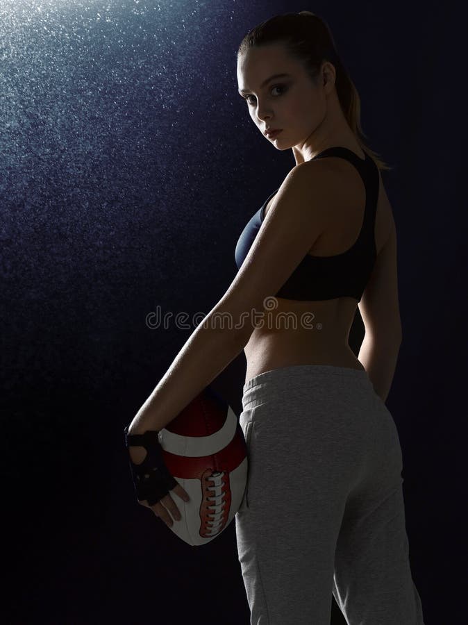 Een meisje in een sportenkostuum bevindt zich met een bal stock foto Een meisje in een sportenkostuum bevindt zich met een bal stock foto