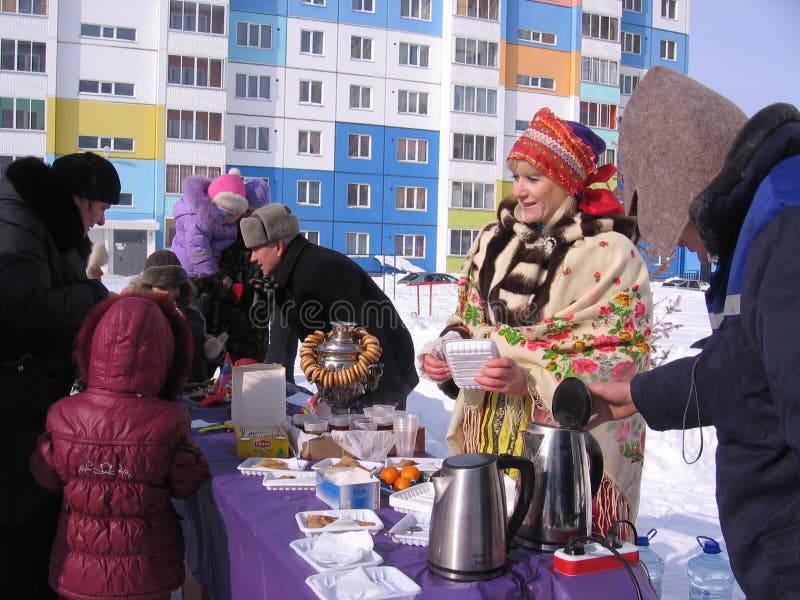 Een menigte van mensenmannen, de kinderen en de vrouwen nemen voedsel van straatventers op vakantie in Novosibirsk in de winter stock afbeelding Een menigte van mensenmannen, de kinderen en de vrouwen nemen voedsel van straatventers op vakantie in Novosibirsk in de winter stock afbeelding