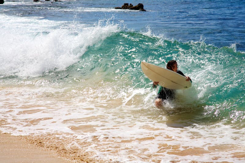 Een mens die bij Groot Strand in Maui skimboarding royalty-vrije stock foto Een mens die bij Groot Strand in Maui skimboarding royalty-vrije stock foto