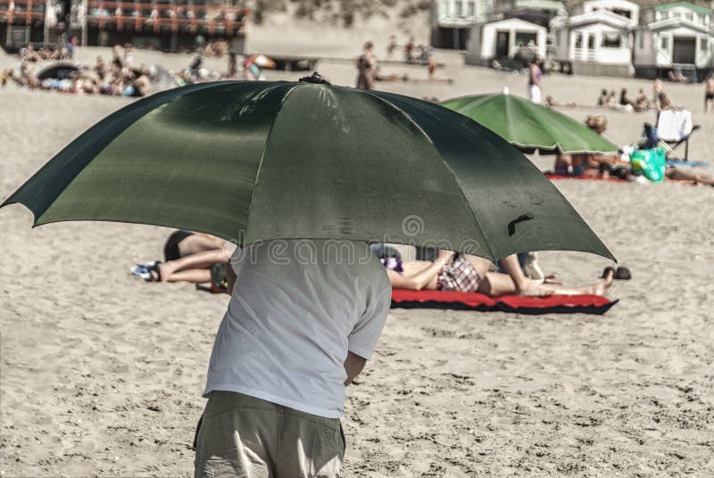 Een mens die een groene paraplu houden stock afbeelding Een mens die een groene paraplu houden stock afbeelding