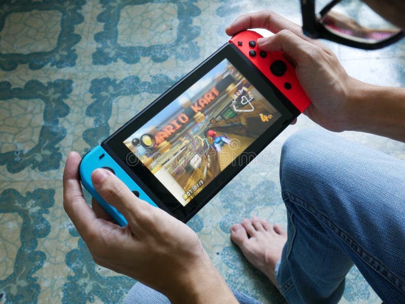 Een mens die Mario Kart 8 Luxe op Nintendo-Schakelaar spelen royalty-vrije stock afbeeldingen Een mens die Mario Kart 8 Luxe op Nintendo-Schakelaar spelen royalty-vrije stock afbeeldingen