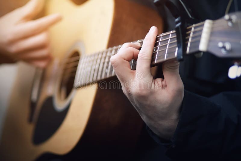 Een mens die op akoestische zes-koord gitaar spelen, die zijn handsnaren een houden royalty-vrije stock afbeelding Een mens die op akoestische zes-koord gitaar spelen, die zijn handsnaren een houden royalty-vrije stock afbeelding
