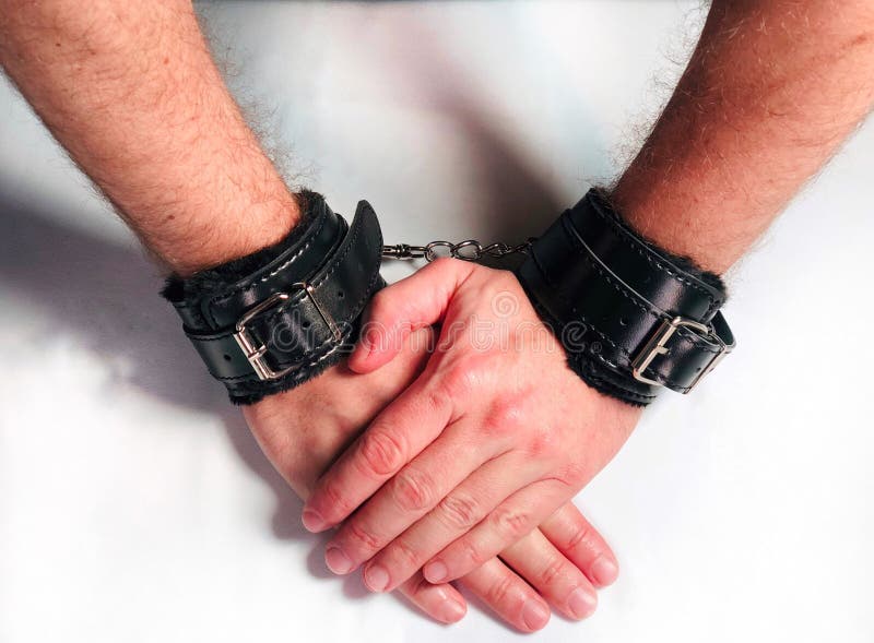 Een mens overhandigt het dragen van zwarte bont het stuk speelgoed van het leergeslacht handcuffs royalty-vrije stock afbeeldingen Een mens overhandigt het dragen van zwarte bont het stuk speelgoed van het leergeslacht handcuffs royalty-vrije stock afbeeldingen
