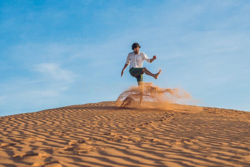 Een mens schopt zand in een rode woestijn Plons van woedeconcept stock foto's Een mens schopt zand in een rode woestijn Plons van woedeconcept stock foto's