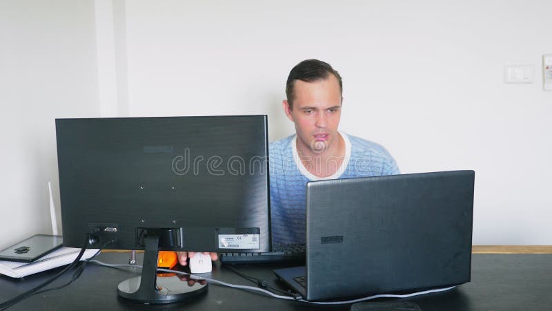 Een mensenzitting bij een bureau thuis, thuis werkend computer en laptop