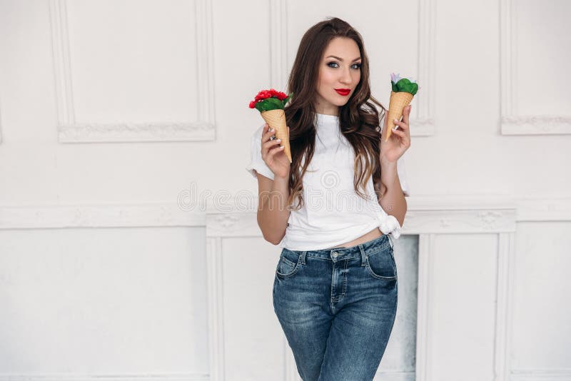 Een mooi donker-haired meisje in modieuze kleren met rode heldere lippen onderzoekt ongebruikelijke voorwerpen van decor, binnen royalty-vrije stock afbeeldingen Een mooi donker-haired meisje in modieuze kleren met rode heldere lippen onderzoekt ongebruikelijke voorwerpen van decor, binnen royalty-vrije stock afbeeldingen