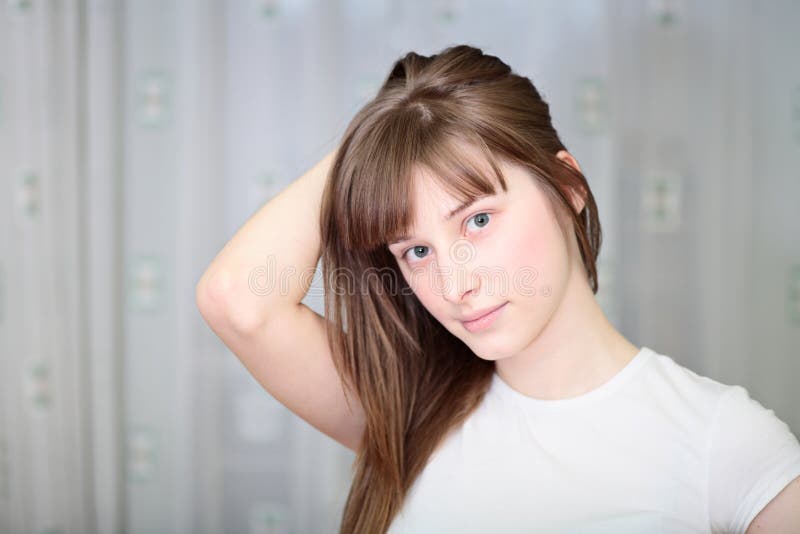 Een ontspannen Jonge Vrouw die met Hand op Kin glimlacht stock fotografie Een ontspannen Jonge Vrouw die met Hand op Kin glimlacht stock fotografie