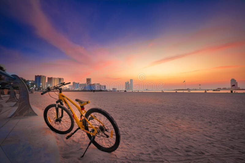 Een oranje kleurenfiets parkeert in het cornichestrand Abu Dhabi royalty-vrije stock foto Een oranje kleurenfiets parkeert in het cornichestrand Abu Dhabi royalty-vrije stock foto