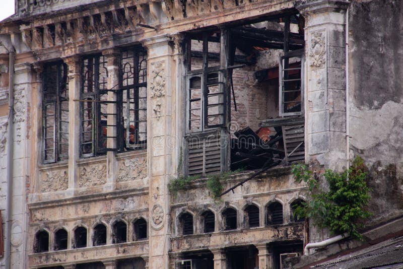 Een oud, bederven hystorisch gebouw met sporen van vuur, roet op de muren dicht bij de ramen
