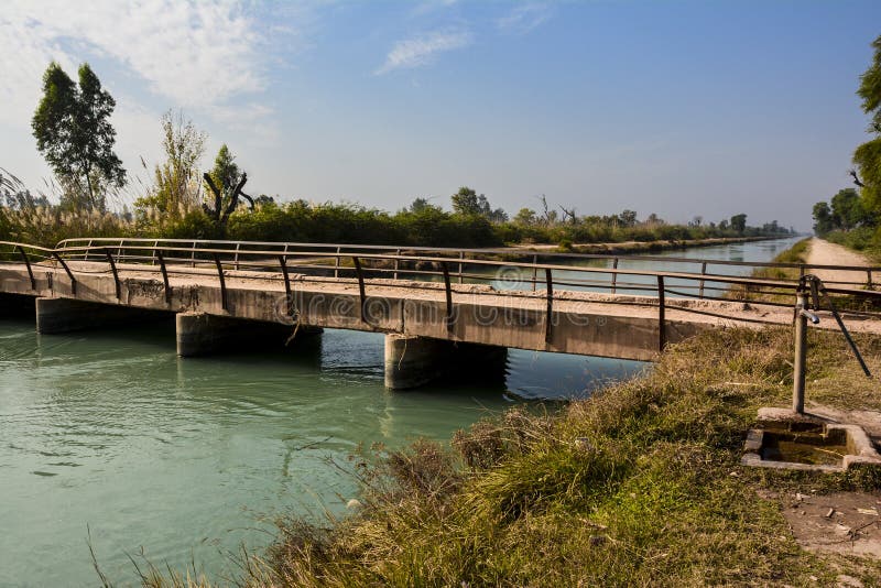 An old bridge on Mohajir Branch Canal at Golewali Shadia road in northern Punjab Pakistan. A peaceful and unique view of tap, bridge and canal during beautiful summer. An old bridge on Mohajir Branch Canal at Golewali Shadia road in northern Punjab Pakistan. A peaceful and unique view of tap, bridge and canal during beautiful summer.