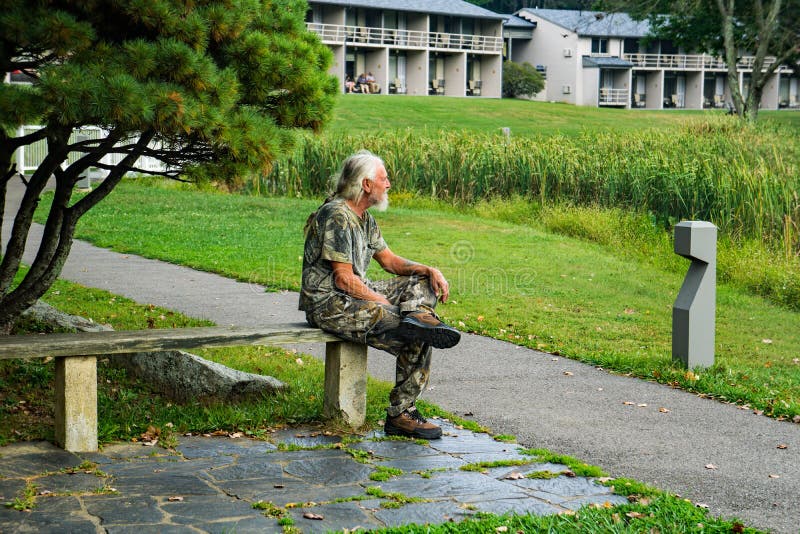 Een oudere man met een witte baard op een bank royalty-vrije stock foto Een oudere man met een witte baard op een bank royalty-vrije stock foto