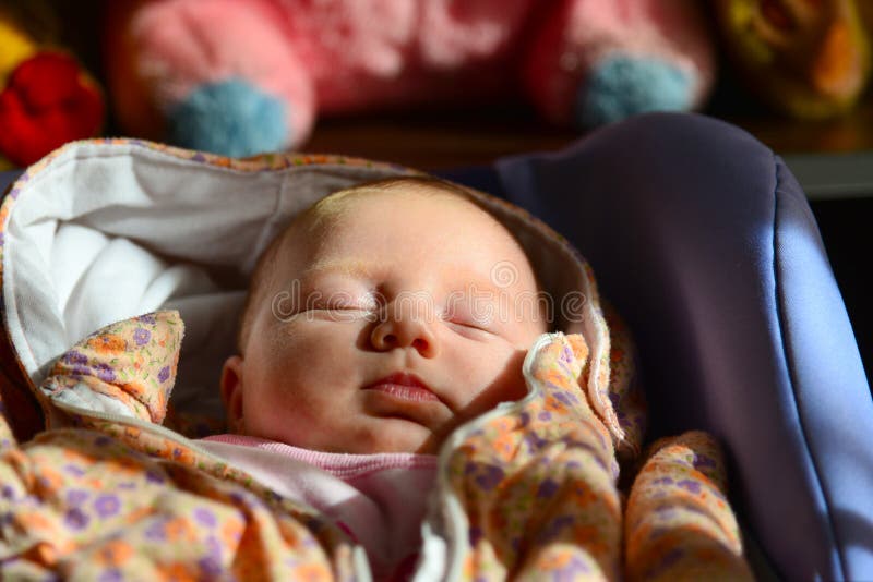 Een pasgeboren baby ligt en slaap in een wandelwagen tegen de achtergrond van het zachte speelgoed van kinderen stock foto's Een pasgeboren baby ligt en slaap in een wandelwagen tegen de achtergrond van het zachte speelgoed van kinderen stock foto's