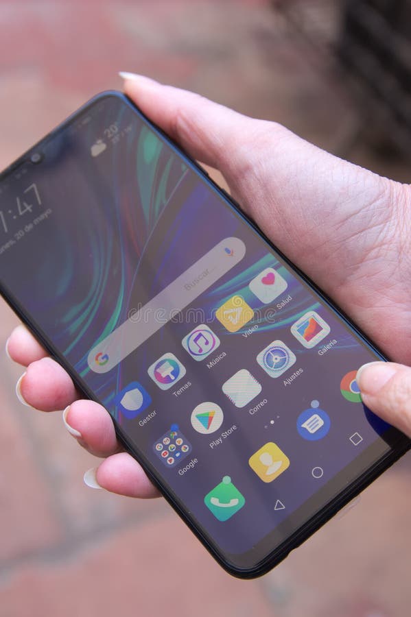 Een persoon die een smartphone van het Chinese bedrijf Huawei drijven stock afbeelding Een persoon die een smartphone van het Chinese bedrijf Huawei drijven stock afbeelding