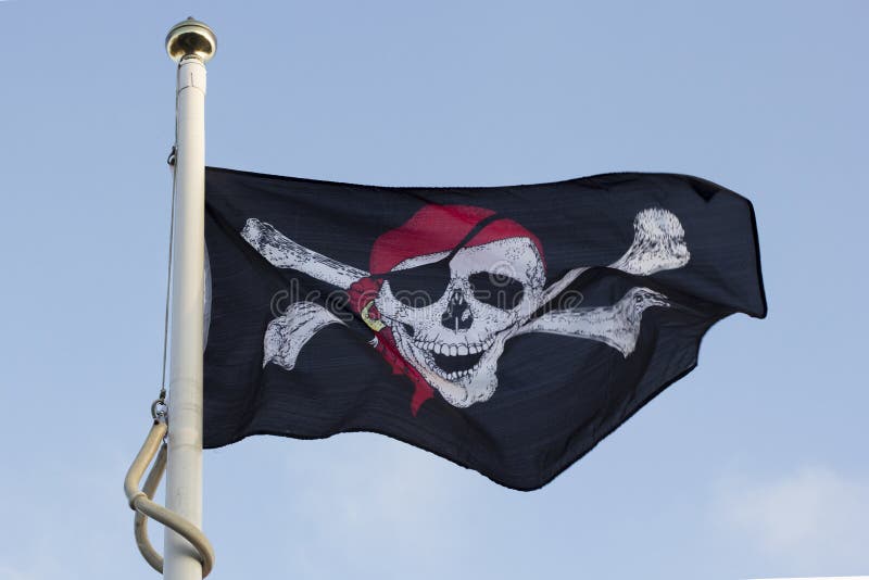 Een piraatvlag die op een zonnige dag vliegen stock afbeelding Een piraatvlag die op een zonnige dag vliegen stock afbeelding
