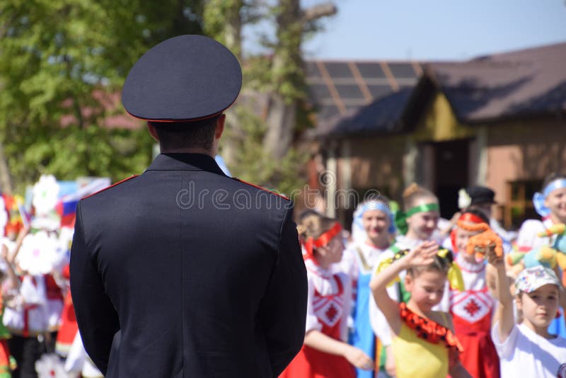 Een politieagent, die de kalmte van burgers bij een feestelijke optocht schreeuwt Het vieren van fir van Mei, de dag van stock fotografie Een politieagent, die de kalmte van burgers bij een feestelijke optocht schreeuwt Het vieren van fir van Mei, de dag van stock fotografie