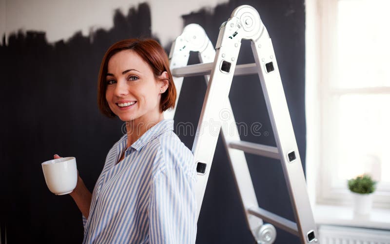 Een portret van de jonge zwarte van de vrouwen schilderende muur Een opstarten van kleine onderneming stock foto's Een portret van de jonge zwarte van de vrouwen schilderende muur Een opstarten van kleine onderneming stock foto's