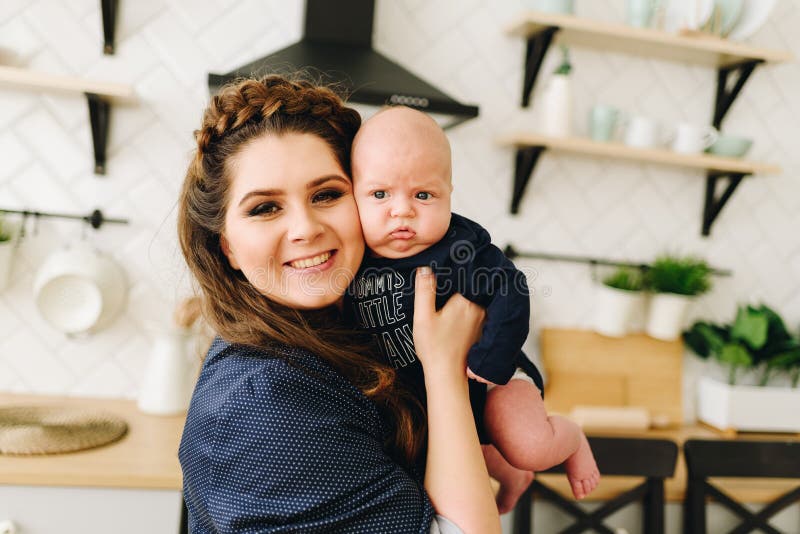 Een portret van jonge mooie vrouw die haar koesteren weinig baby en het glimlachen stock afbeeldingen Een portret van jonge mooie vrouw die haar koesteren weinig baby en het glimlachen stock afbeeldingen