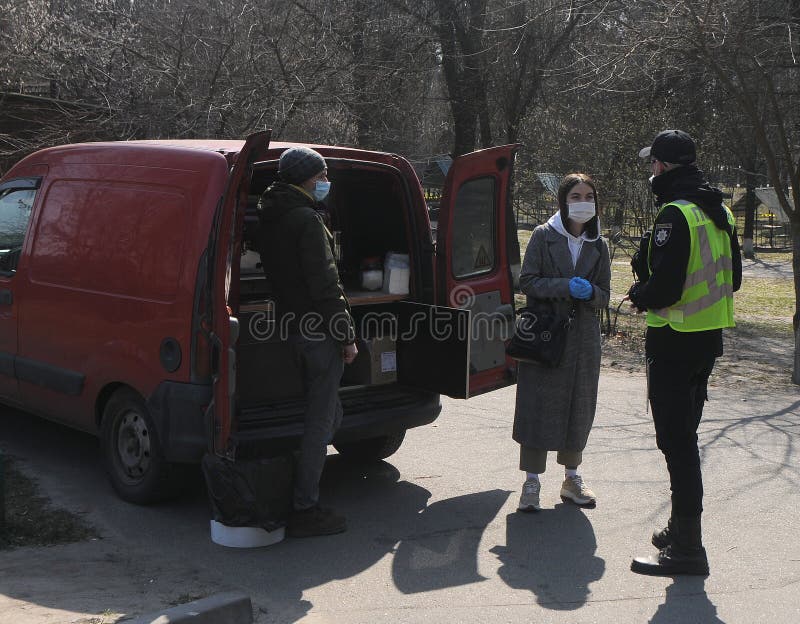 A law enforcement officer communicates with sellers of coffee near a mobile coffee shop, in Kiev, April 4, 2020. A law enforcement officer communicates with sellers of coffee near a mobile coffee shop, in Kiev, April 4, 2020.