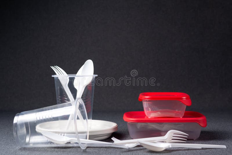 Een reeks plastic werktuigen Plastic koppen, platen, vorken, lepels en plastic containers op een grijze achtergrond Tegen plastie royalty-vrije stock afbeelding Een reeks plastic werktuigen Plastic koppen, platen, vorken, lepels en plastic containers op een grijze achtergrond Tegen plastie royalty-vrije stock afbeelding