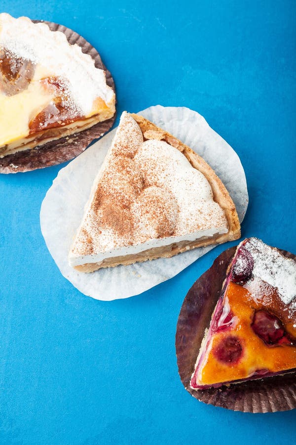 Een reeks zoete stukken van cake op een blauwe achtergrond stock foto Een reeks zoete stukken van cake op een blauwe achtergrond stock foto