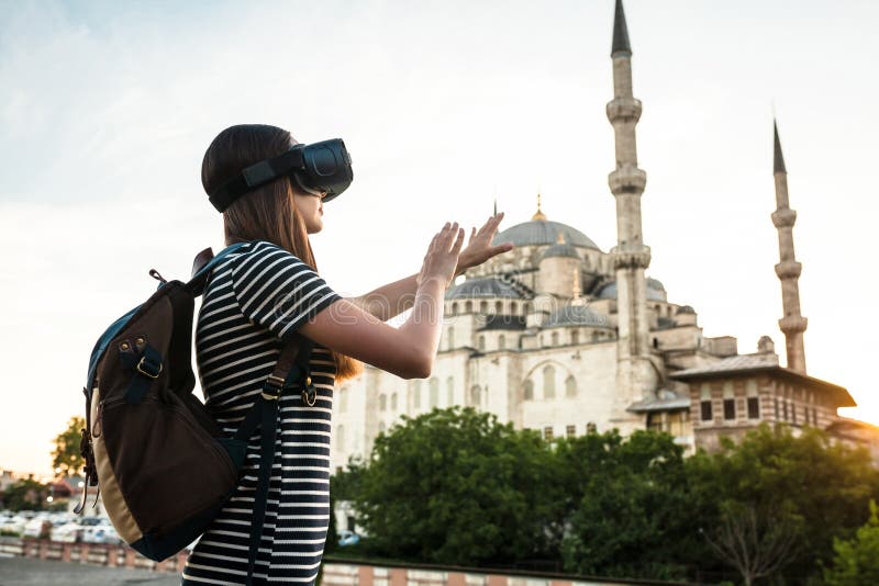 A traveler with virtual reality glasses. The concept of virtual travel around the world. In the background, the blue mosque Sultanahmet in Istanbul. Modern imaging technology. A traveler with virtual reality glasses. The concept of virtual travel around the world. In the background, the blue mosque Sultanahmet in Istanbul. Modern imaging technology.