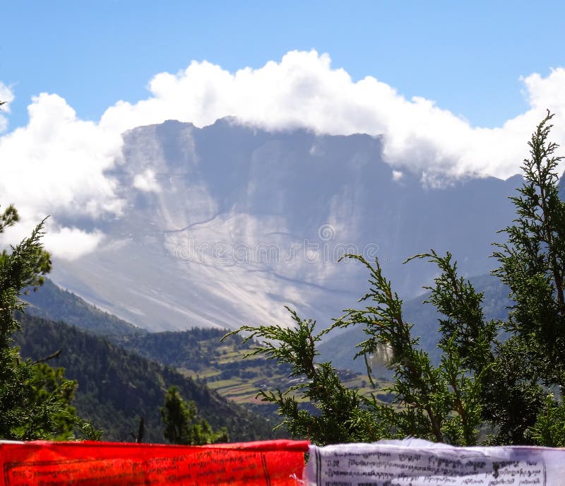 Een rode en witte Boeddhistische gebedvlag met alpines en steile moun stock afbeelding Een rode en witte Boeddhistische gebedvlag met alpines en steile moun stock afbeelding