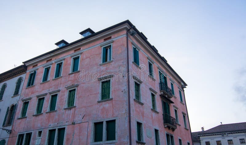 Een roze palazzo uit de oudheid in het centrum van belluno , de kleine stad van venetië