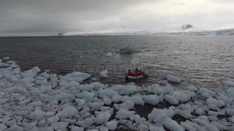 Een rubberboot met toeristen voer aan stukken van ijs dichtbij de kust Andreev