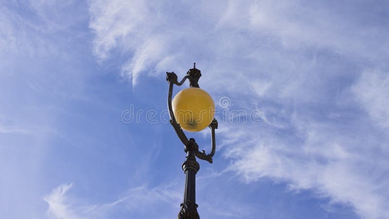 A spherical shaped vintage street lamp with metal decorations and the sky in background Gubbio, Umbria, Italy. A spherical shaped vintage street lamp with metal decorations and the sky in background Gubbio, Umbria, Italy