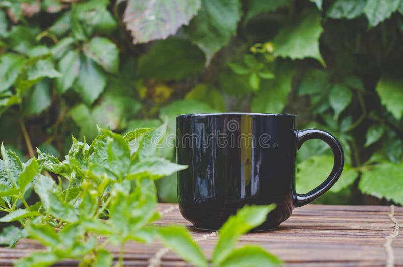 Een solo lege witte koffiemok op de rand van de bamboelijst royalty-vrije stock afbeelding Een solo lege witte koffiemok op de rand van de bamboelijst royalty-vrije stock afbeelding