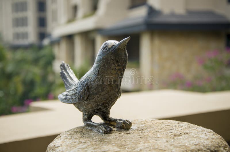 Een Standbeeld van de Bronsvogel op een rots stock afbeelding