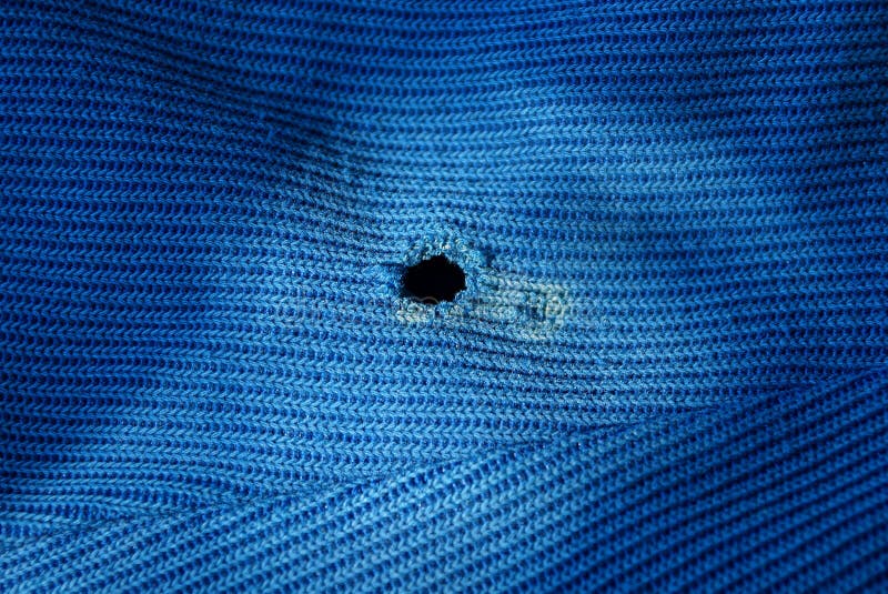 Een stuk van blauwe oude doek met een zwart gat royalty-vrije stock afbeeldingen Een stuk van blauwe oude doek met een zwart gat royalty-vrije stock afbeeldingen