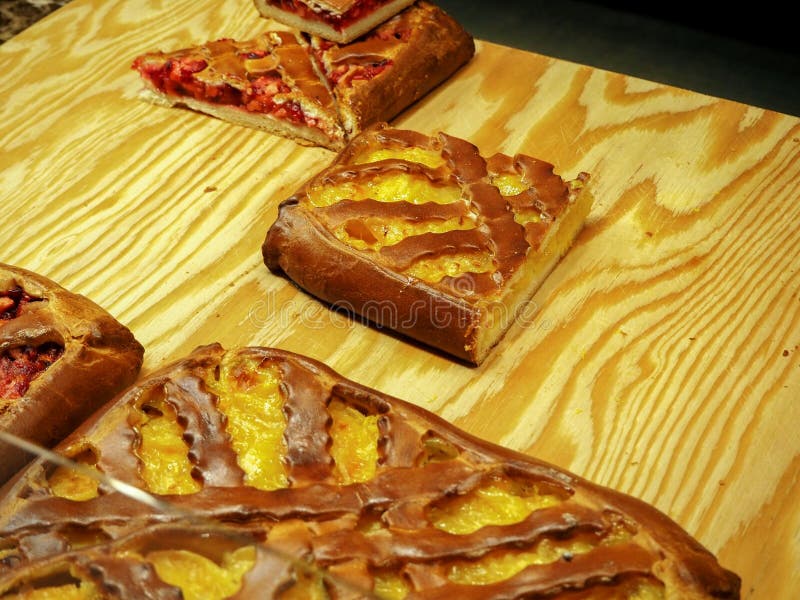 Een stuk van vlaai met het gele en rode vullen op een houten raad royalty-vrije stock foto Een stuk van vlaai met het gele en rode vullen op een houten raad royalty-vrije stock foto