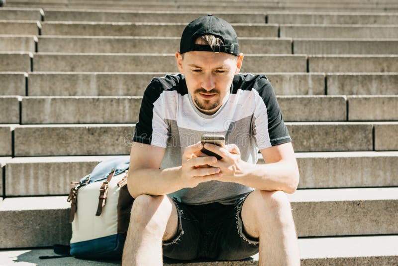 Een toerist of een student zitten op de treden, de rust en het gebruik een mobiele telefoon stock foto's Een toerist of een student zitten op de treden, de rust en het gebruik een mobiele telefoon stock foto's
