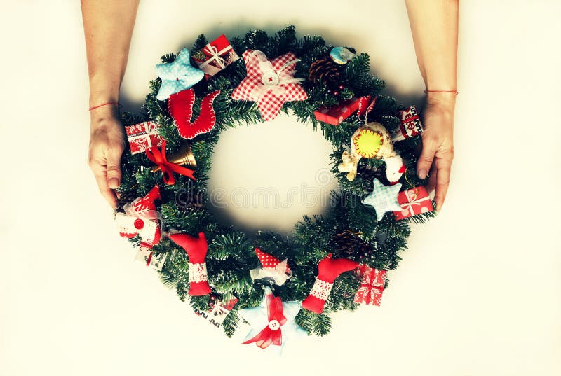 Een verfraaide Kerstmiskroon in de handen van een vrouw Geïsoleerdj op witte achtergrond royalty-vrije stock foto Een verfraaide Kerstmiskroon in de handen van een vrouw Geïsoleerdj op witte achtergrond royalty-vrije stock foto