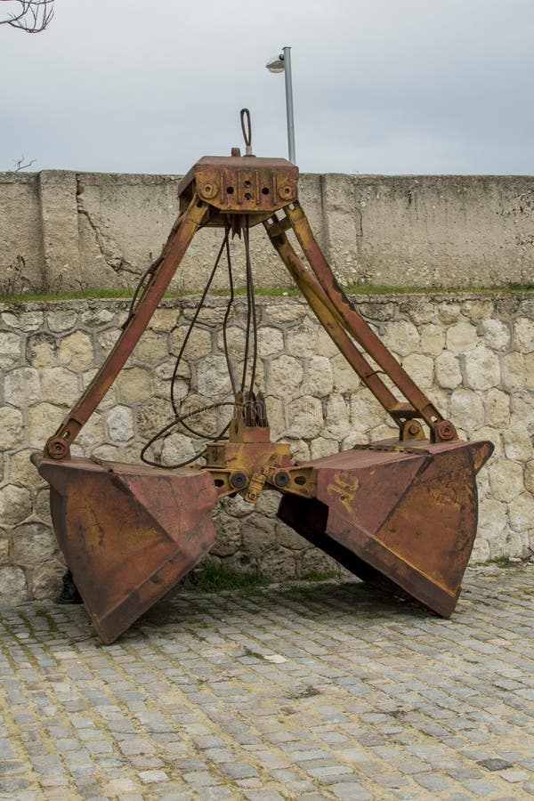 Een verlaten oude dubbele emmer van een graafwerktuig bij de zeepost in Varna royalty-vrije stock fotografie Een verlaten oude dubbele emmer van een graafwerktuig bij de zeepost in Varna royalty-vrije stock fotografie