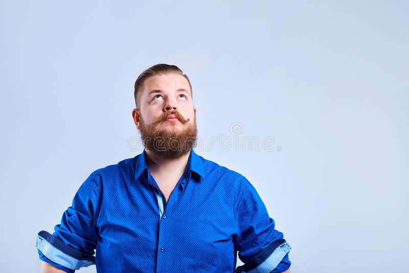 Een vette, gebaarde mens kijkt omhoog met een ernstige uitdrukking van emotie stock afbeelding Een vette, gebaarde mens kijkt omhoog met een ernstige uitdrukking van emotie stock afbeelding