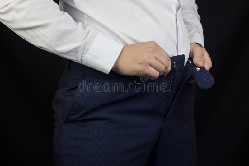 Een vette mens in een wit overhemd en de broeken kunnen niet zijn broek, overgewicht, close-ups vastmaken royalty-vrije stock foto Een vette mens in een wit overhemd en de broeken kunnen niet zijn broek, overgewicht, close-ups vastmaken royalty-vrije stock foto