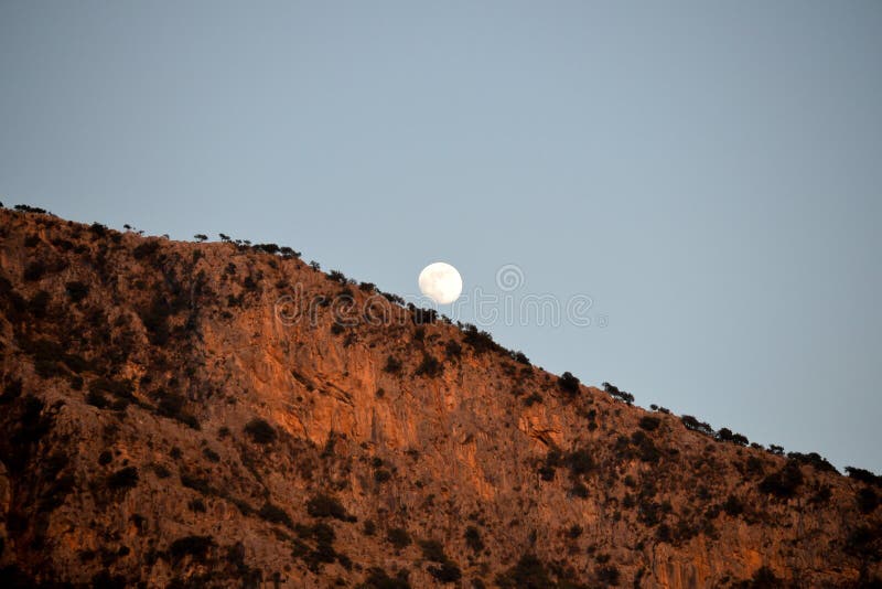 Een volle maan neemt over de bergen toe De hemel van de avond stock fotografie Een volle maan neemt over de bergen toe De hemel van de avond stock fotografie