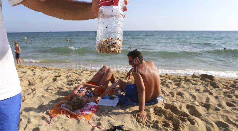 Een vrijwilligersstomp van de showsigaret plukte van het strand tijdens het milieu schoonmaken op het strand in het detail van Ma royalty-vrije stock afbeeldingen Een vrijwilligersstomp van de showsigaret plukte van het strand tijdens het milieu schoonmaken op het strand in het detail van Ma royalty-vrije stock afbeeldingen