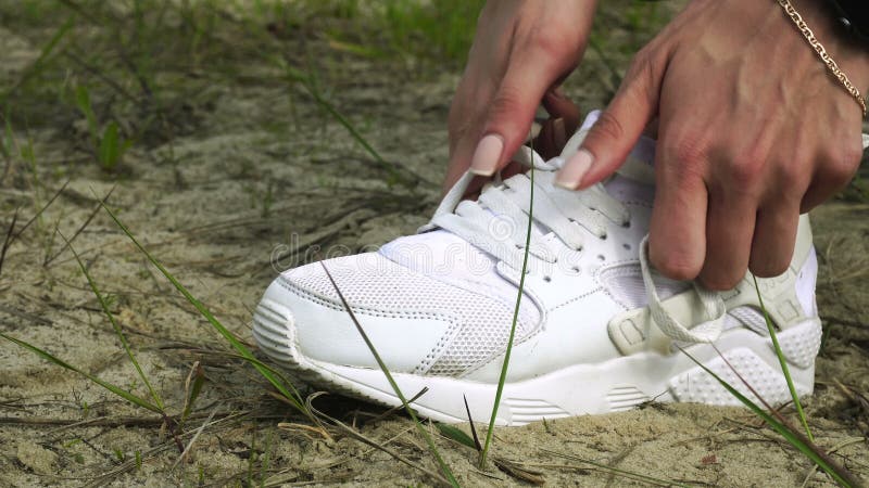 Een vrouw bindt een witte schoenveter stock video