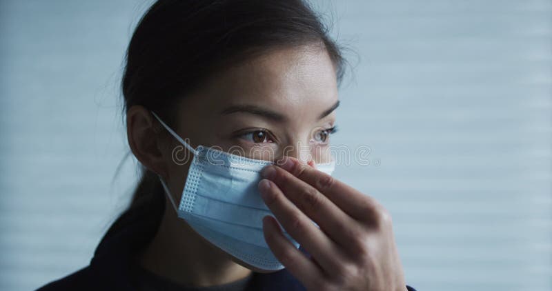 Een vrouw die een operatief gezichtsmasker aantrekt ter bescherming tegen het coronavirus. langzame beweging van de rode filmcamer