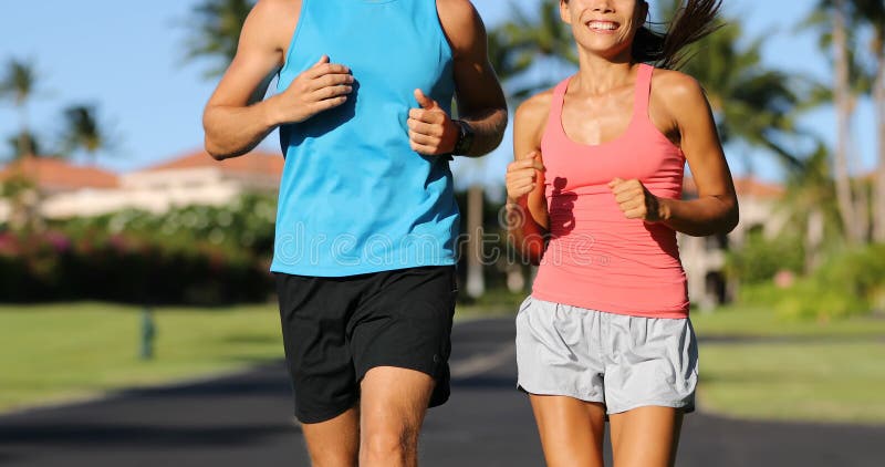 Een vrouw en een man die op de zomerdag in een rijke mooie buurt rondrennen en joggen