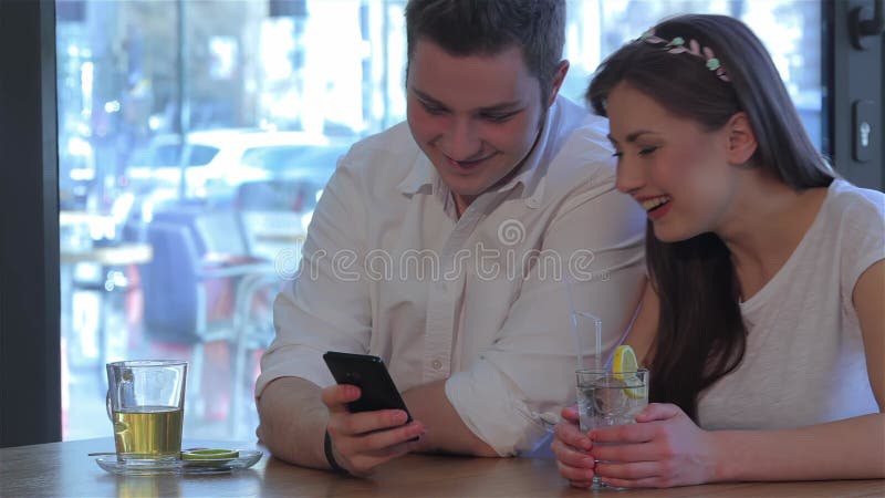 Een vrouw lacht om te kijken naar de mannentelefoon