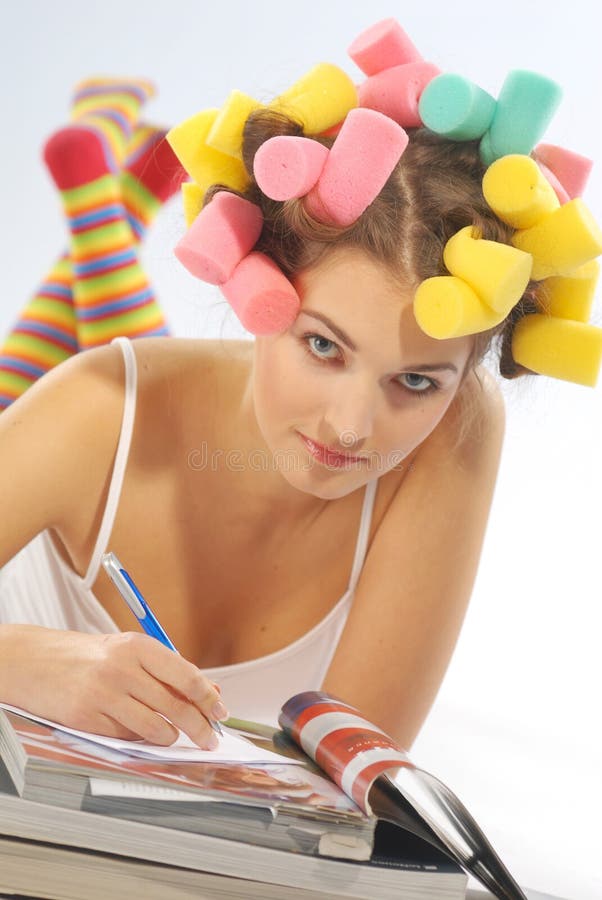 A writing woman with curlers on her head. A writing woman with curlers on her head