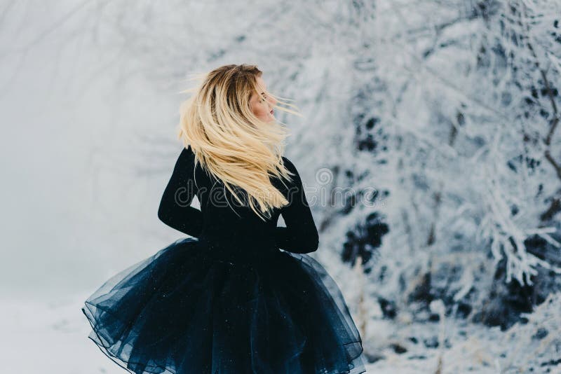 Een vrouw met schitterend haar gaat in de winter in het Park achteruit stock foto's Een vrouw met schitterend haar gaat in de winter in het Park achteruit stock foto's